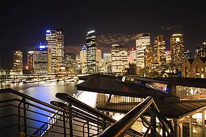 Night cityscape with buildings and harbor in Sydney, Australia.