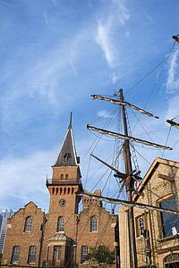 Low angle view of Australian Steam Navigation Company building and mast of sailboat in Sydney, Australia.