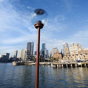 Lamppost in Sydney Cove with city skyline and water in Sydney, Australia.