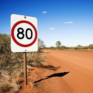 Australian kilometer per hour speed limit sign by rural dirt road