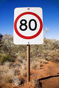 Australian kilometer per hour speed limit sign by rural dirt road