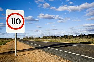 Speed limit kilometer per hour road sign by road in rural Australia.