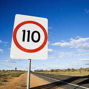 Speed limit kilometer per hour road sign by road in rural Australia.