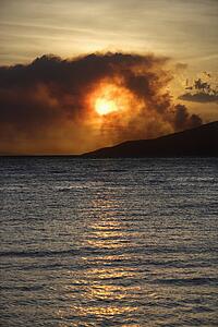 Dark clouds at sunset over water