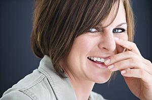 Woman smiling with hand to mouth