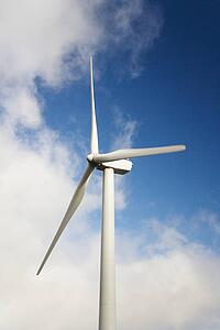 Wind turbine against blue sky and clouds