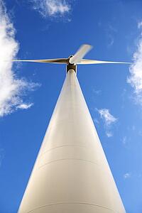 Perspective shot of wind turbine against blue sky