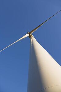 Perspective shot of wind turbine against blue sky