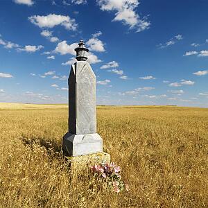 Stone burial monument in field.