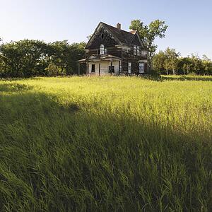 Abandoned farm house in rural field