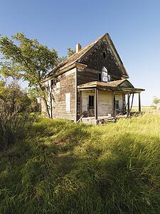 Abandoned farm house in rural field