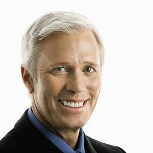 Middle aged Caucasian man in business suit smiling at viewer.