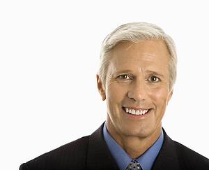 Middle aged Caucasian man in business suit smiling at viewer.