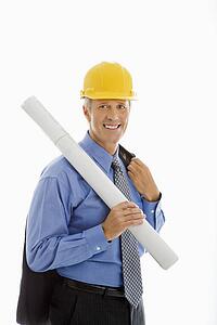Businessman holding blueprints and wearing hard hat