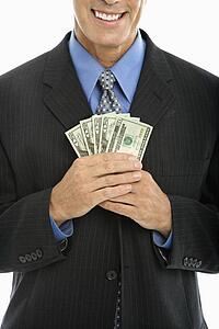 Middle aged businessman holding fist full of cash