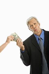 Woman holding money with businessman making facial expression