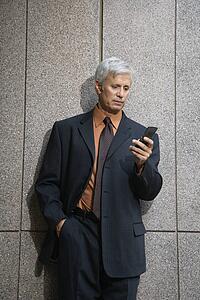 Businessman looking down at cell phone