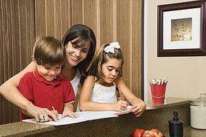 Mother helping children with homework