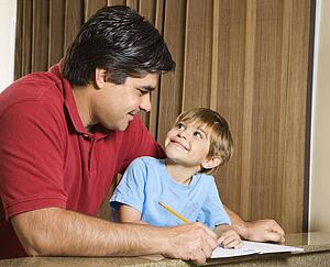 Father and son doing homework and making eye contact