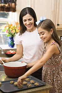 Mother and daughter in kitchen making cookies