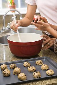 Mother and child in kitchen making cookies