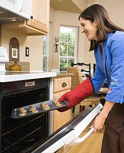 Woman putting cookies into oven