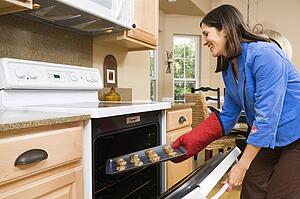 Woman putting cookies into oven