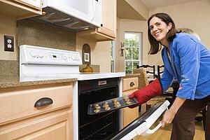 Woman putting cookies into oven