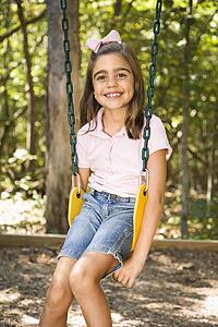 Girl sitting on swing smiling