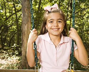 Girl sitting on playground swing