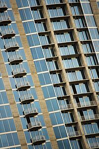 Exterior of high rise building with mirrored windows and balconies.