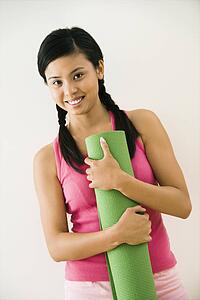 Woman holding exercise mat