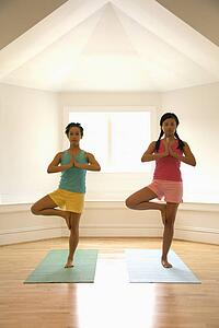 Women balancing doing yoga tree pose