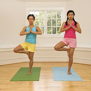 Women balancing doing yoga tree pose