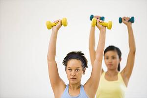 Young women at gym lifting hand weights