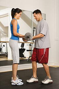 Man and woman lifting weights in gym