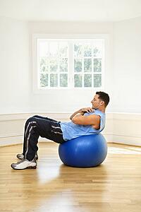 Man doing sit ups on balance ball