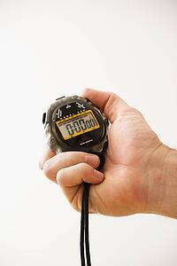 Close-up of adult male hand holding stopwatch