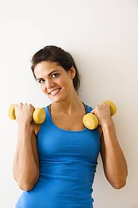 Woman holding hand weights and smiling