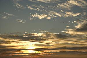 Sun in blue sky with clouds.