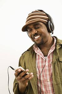 Man wearing knit hat and listening to headphones and mp3 player