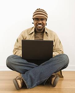 Man sitting on floor with a laptop computer