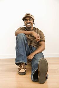 Man wearing hat sitting on floor