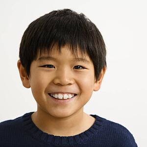 Portrait of young Asian boy smiling.