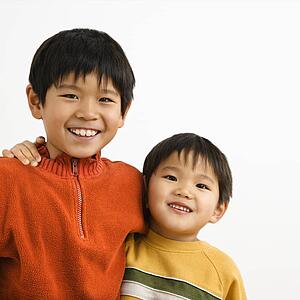 Brothers with arms around each other smiling.