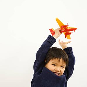 Young boy playing with plastic toy airplane