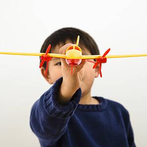 Young boy playing with plastic toy airplane