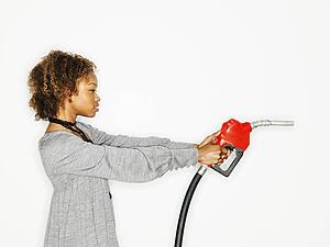 Woman holding gas pump nozzle like a gun
