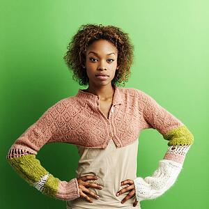 Woman standing against green background with hands on hips