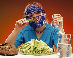 Women wearing sports equipment eating celery